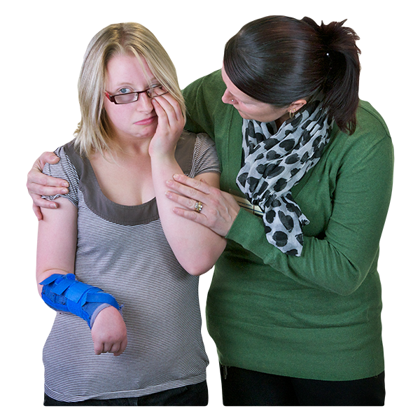 a parent puts her arm around a young girl who is crying