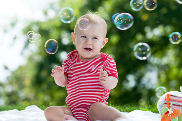 Happy baby playing with bubbles